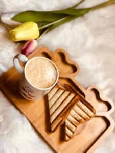 a cup of coffee on a wooden tray with flowers at Airport Hotel Peebles in New Delhi