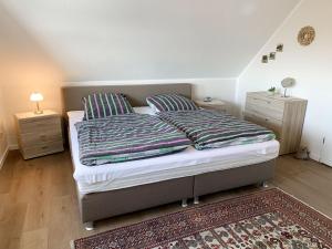 ein Bett mit zwei Kissen und einem Teppich in einem Schlafzimmer in der Unterkunft Holiday Home Kleine Möwe by Interhome in Timmel