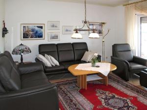 ein Wohnzimmer mit einem Sofa, Stühlen und einem Tisch in der Unterkunft Holiday Home Kleine Möwe by Interhome in Timmel