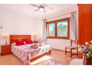 Un dormitorio con una cama con almohadas rojas y una ventana en Apartment Vista Playa - LOM180 by Interhome, en Cala Santanyi