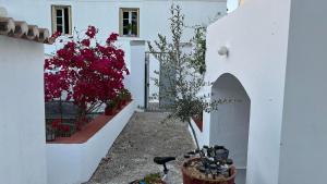 a white building with flowers in a courtyard at Traditional Detached House in Spetses