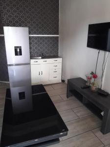 una cucina con frigorifero bianco e tavolo di Mauya Guesthouse a Kuilsrivier
