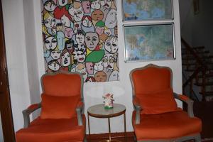 Caretta Caretta Hotel في داليان: كرسيان برتقاليان وطاولة في الغرفة