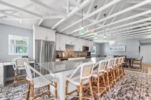 een keuken met witte kasten en een bar met stoelen bij Go to the beach from expansive heated pool home in Fort Myers Beach