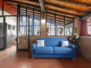 a blue couch in a room with windows at Apartment Serena by Interhome in Piedimonte Etneo +26 photos