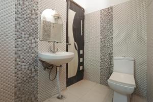 a bathroom with a sink and a toilet and a mirror at Airport Hotel Peebles in New Delhi