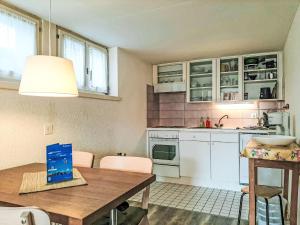 a kitchen with white cabinets and a wooden table at Apartment Helene Apt- Hella by Interhome in Wengen