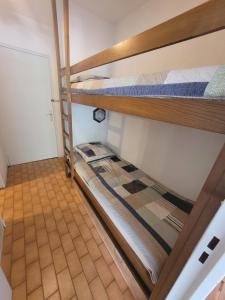 2 Etagenbetten in einem Zimmer mit Fliesenboden in der Unterkunft Studio cabine au centre ville à 150m de la plage N1 66 in La Grande-Motte