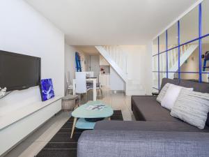 a living room with a couch and a tv at Apartment Villa M-Thérèse Promenade Anglais by Interhome in Nice