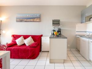 a living room with a red couch in a kitchen at Apartment Les Pêcheurs-4 by Interhome in Mimizan-Plage