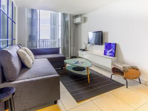 a living room with a couch and a tv at Apartment Villa M-Thérèse Promenade Anglais by Interhome in Nice