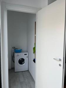 uma lavandaria branca com máquina de lavar e secar roupa em Nonna Gina House em Tortolì
