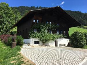 a building with a gambrel roof and a brick driveway at Apartment Aerneli- Chalet by Interhome in Gstaad