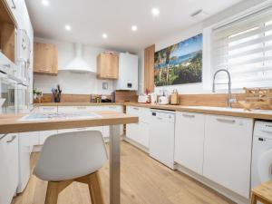 cocina con armarios blancos y encimera de madera en Holiday Home Les Dunes-2 by Interhome, en Quiberon