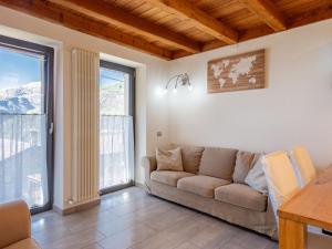 salon z kanapą i dwoma dużymi oknami w obiekcie Holiday Home Marcello by Interhome w mieście Sueglio