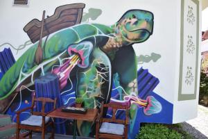 a mural on the side of a building with chairs and a table at Caretta Caretta Hotel in Dalyan