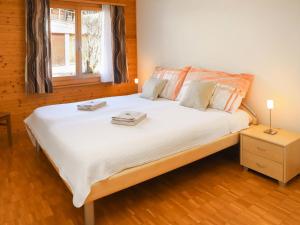 1 dormitorio con 1 cama blanca grande y ventana en Apartment Belmi by Interhome, en Zweisimmen