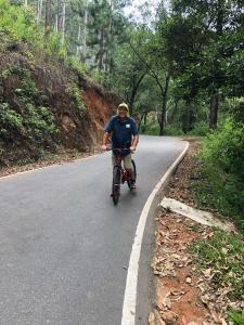 a man riding a bike down a road at Rock n Fall Nature Resort in Ella