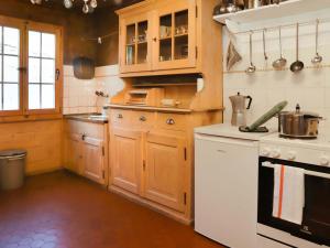uma cozinha com armários de madeira e um forno de fogão branco em Apartment Chalet Ahorni by Interhome em Hornkessel