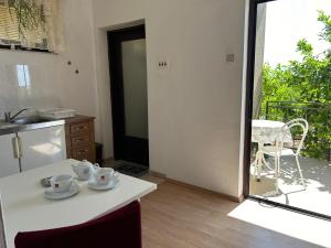 una cocina con una mesa con dos tazas. en 4 Sisters Apartments, en Gradac 41 fotos más