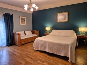 1 dormitorio con 1 cama grande y 1 silla en La Jouvenelle, en Aucey-la-Plaine