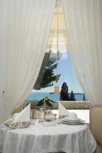 Biały stół z widokiem na ocean w obiekcie Hotel Villa Florida & Suite Apartments w mieście Gardone Riviera