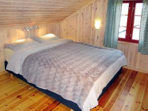 a bedroom with a large bed in a wooden room at Holiday Home Trondbu - SOW106 by Interhome in Madland