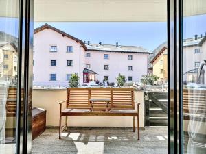 a bench on a balcony with a view of a building at Apartment Chesa Tschierv II 30 by Interhome in Celerina