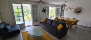 uma sala de estar com um sofá e uma mesa em Le Cagou em Thésée