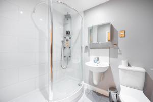 W łazience znajduje się prysznic, toaleta i umywalka. w obiekcie Austin David Executive ExCeL w Londynie