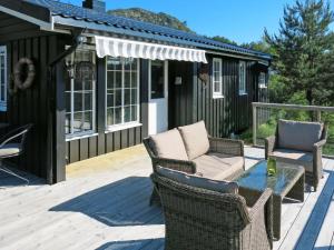 a patio with two chairs and a table on a deck at Chalet Knøttebu - SOW054 by Interhome in Øyuvstad