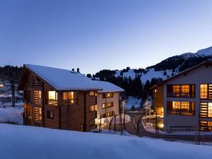 un grand bâtiment avec de la neige sur le sol à côté dans l'établissement Apartment Turrabuel 4-Bett Maisonette by Interhome, à Parpan