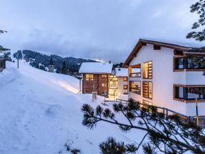 dom na pokrytym śniegiem wzgórzu w śniegu w obiekcie Apartment Turrabuel 4-Bett Maisonette by Interhome w mieście Parpan