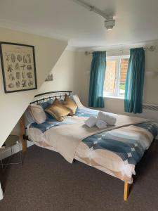 a bedroom with a large bed with blue curtains at The Red Lion Great Offley in Great Offley