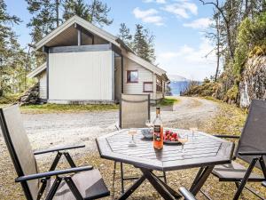 a picnic table with a bottle of wine and a plate of fruit at Holiday Home Veganeset I - FJS294 by Interhome in Balestrand
