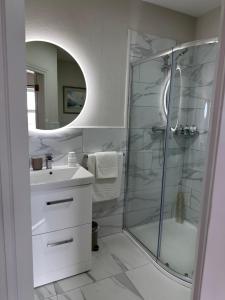 een badkamer met een douche, een wastafel en een spiegel bij Eldon's Bed & Breakfast in Roundstone