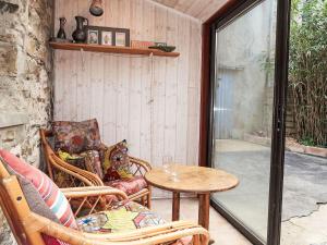 un patio con 2 sillas, una mesa y una ventana en Holiday Home La douce Trégoroise by Interhome en Tréguier