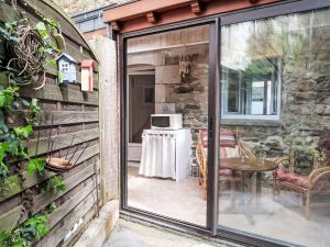 una puerta corredera de cristal que conduce a un patio con mesa en Holiday Home La douce Trégoroise by Interhome en Tréguier