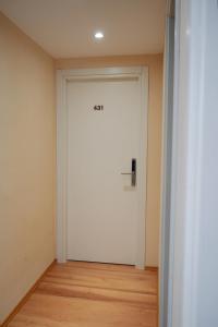 a white door in a room with a wooden floor at Ufo Rooms City Center in Tirana