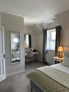 una camera con letto, scrivania e specchio di Eldon's Bed & Breakfast a Roundstone