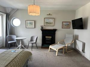 Eldon's Bed & Breakfast في راوندستون: غرفة نوم بها موقد وكراسي وتلفزيون