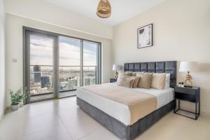 een slaapkamer met een groot bed en een groot raam bij The Downtown Dubai Collection in Dubai