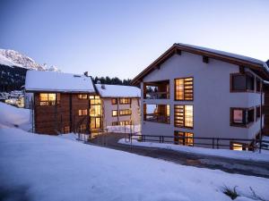 a house in the snow with the lights on at Apartment Turrabuel 7-Bett Deluxe by Interhome in Parpan