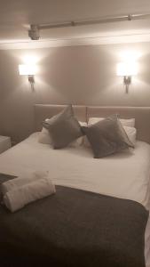 a white bed with two pillows on top of it at The Red Lion Great Offley in Offley