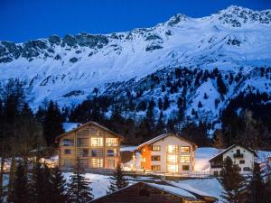 ein großes Gebäude vor einem schneebedeckten Berg in der Unterkunft Apartment Turrabuel 2-Bett Superior by Interhome in Parpan