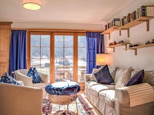 uma sala de estar com sofás e uma grande janela em Apartment Chesa Arpschellas - Reis by Interhome em Zuoz