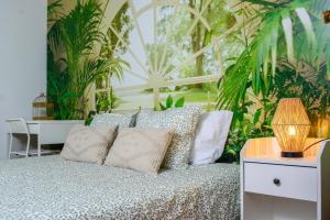 a bedroom with a bed with plants in the background at Live Oporto Rooms in Porto