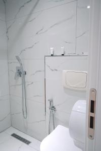 a white bathroom with a shower and a toilet at Ufo Rooms City Center in Tirana