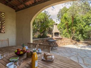 ポルト・ヴェッキオにあるVilla Villa Pavellone by Interhomeの木製テーブル(パティオの上に食べ物付)