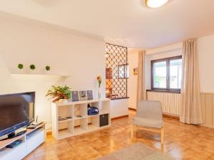a living room with a television and a chair at Apartment Mila by Interhome in Colico